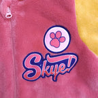 Detail badge met roze pootafdruk en de naam Skye naast de rits
