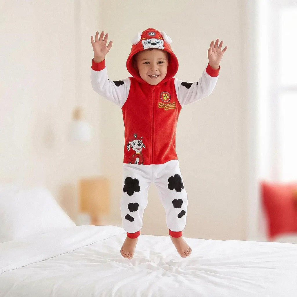 Jongen in Paw Patrol Marshall onesie juicht op bed