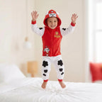 Jongen in Paw Patrol Marshall onesie juicht op bed