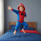 Jongen in Spidey onesie springt op bed