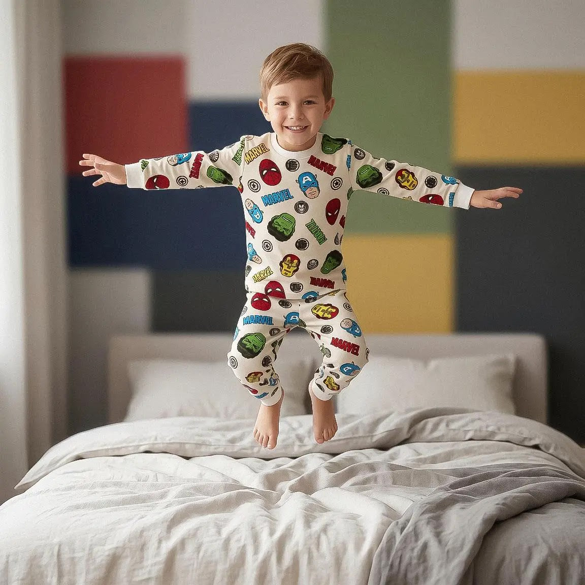 Jongen springt op bed in de crème Marvel Avengers pyjama