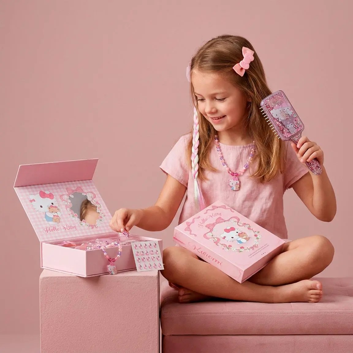 Meisje met Hello Kitty strikje en ketting borstelt haar haar
