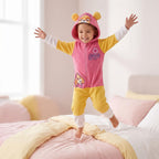 Meisje in Paw Patrol Skye onesie springt vrolijk op bed