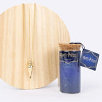 ketting op houten standaard naast het flesje