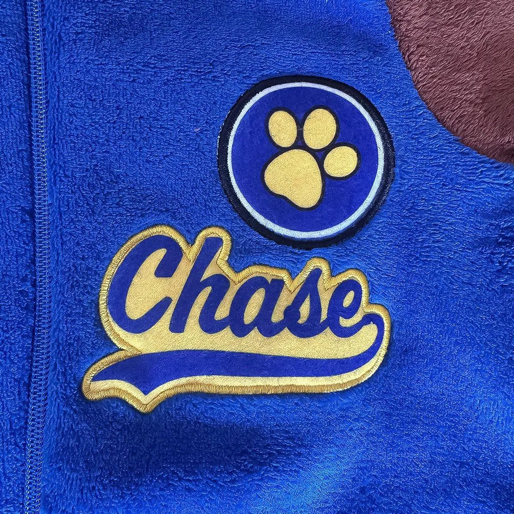 Detail badge met gele pootafdruk en de naam Chase