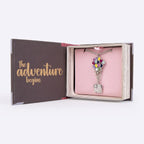 geopend cadeaudoosje met ketting en tekst The adventure begins