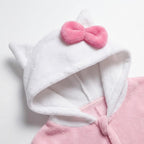 Detail witte capuchon met kattenoortje en roze strik