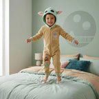 Kind in Star Wars Grogu onesie op bed in een kinderkamer