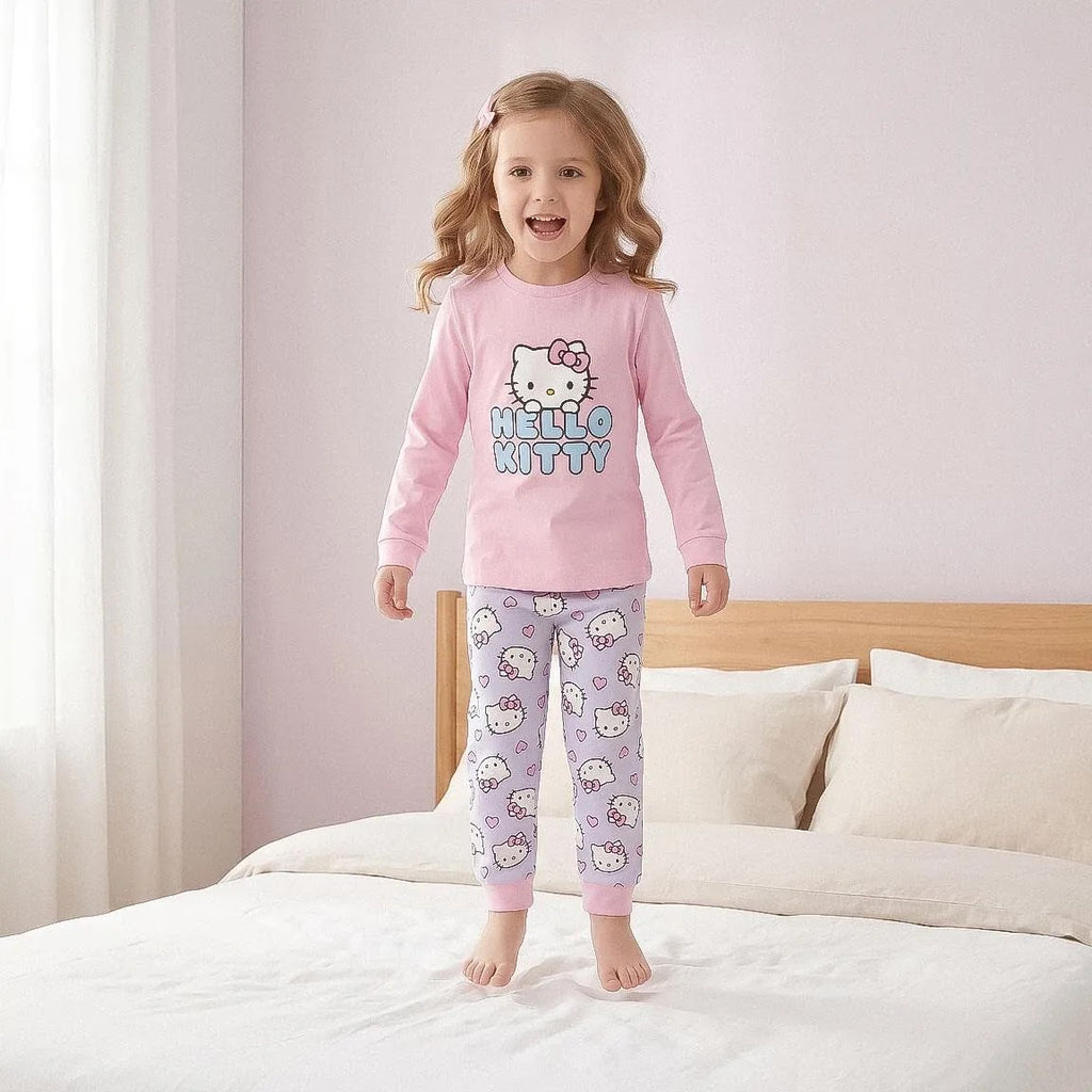 Meisje in roze Hello Kitty pyjama op bed