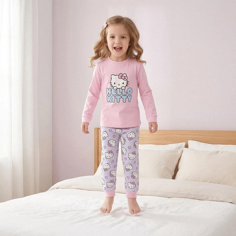 Meisje in roze Hello Kitty pyjama op bed