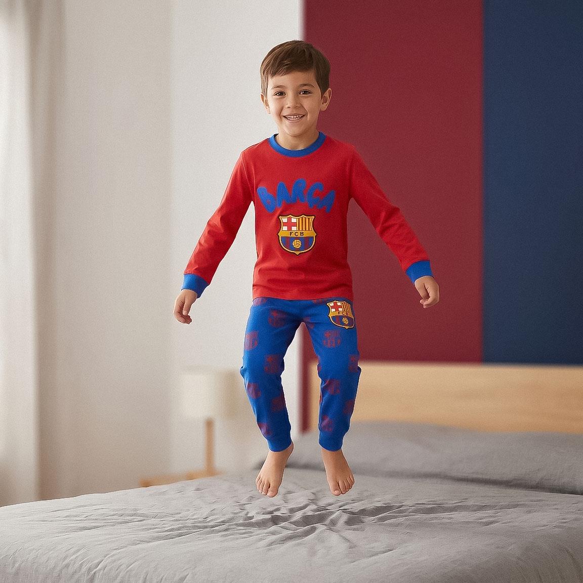 Kind springt op bed in FC Barcelona pyjama