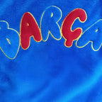 Geborduurde BARÇA letters op de badjas detail