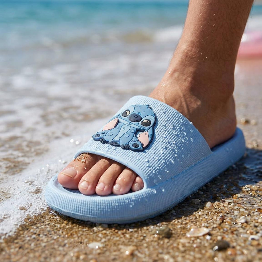 Kind draagt Disney Stitch slippers op het strand.